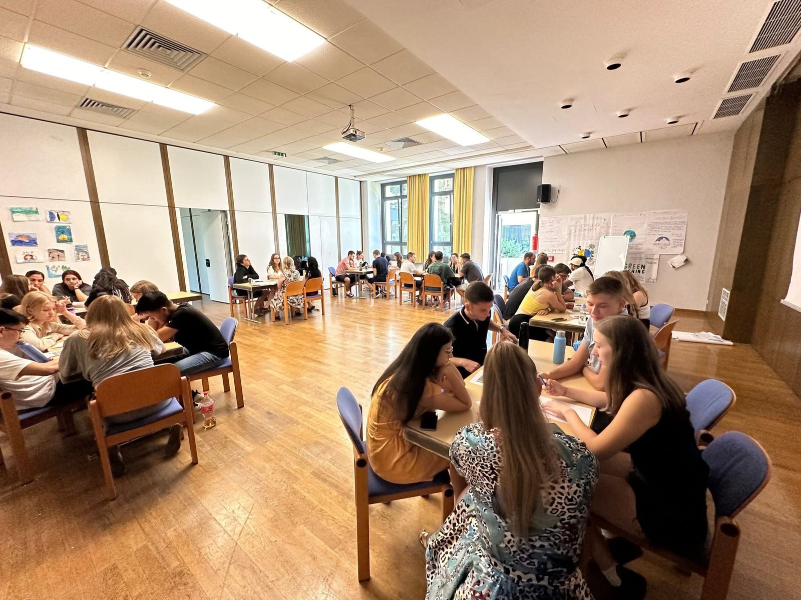 Small groups at work during a youth exchange, with posters on greenwashing and the circular economy