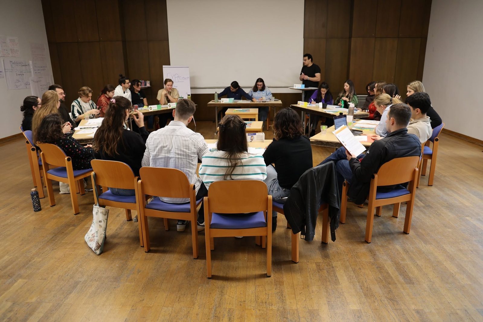 Youth workers in a role-play simulation, with each table playing a stakeholder